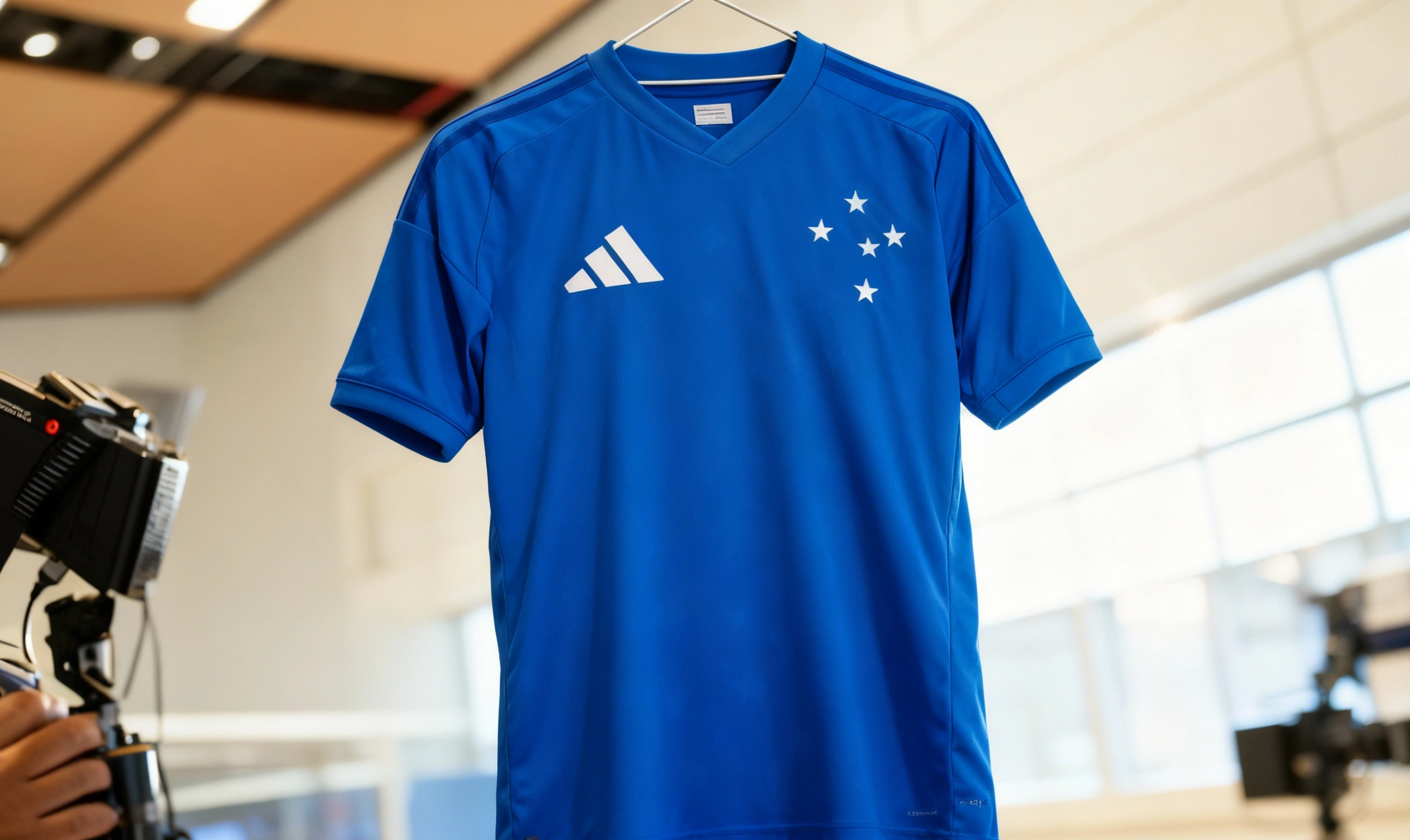 Camiseta oficial del Cruzeiro 2026 suspendida para exhibición, mostrando los detalles del diseño conmemorativo